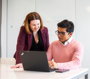 Two people working together on a laptop.