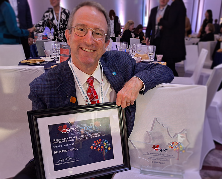 Marc Nantel, PhD, with his award trophy and certificate Trailblazer Award in Innovation Policy.