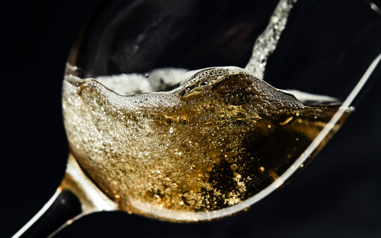 Close up of white wine being poured into a wine glass